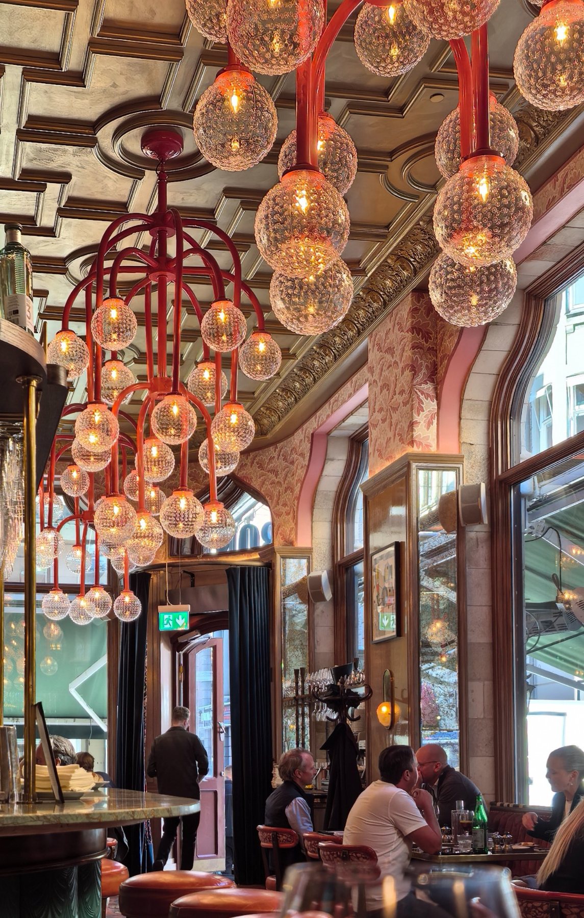 Warm red pendant lights filling the ceiling of a restaurant.