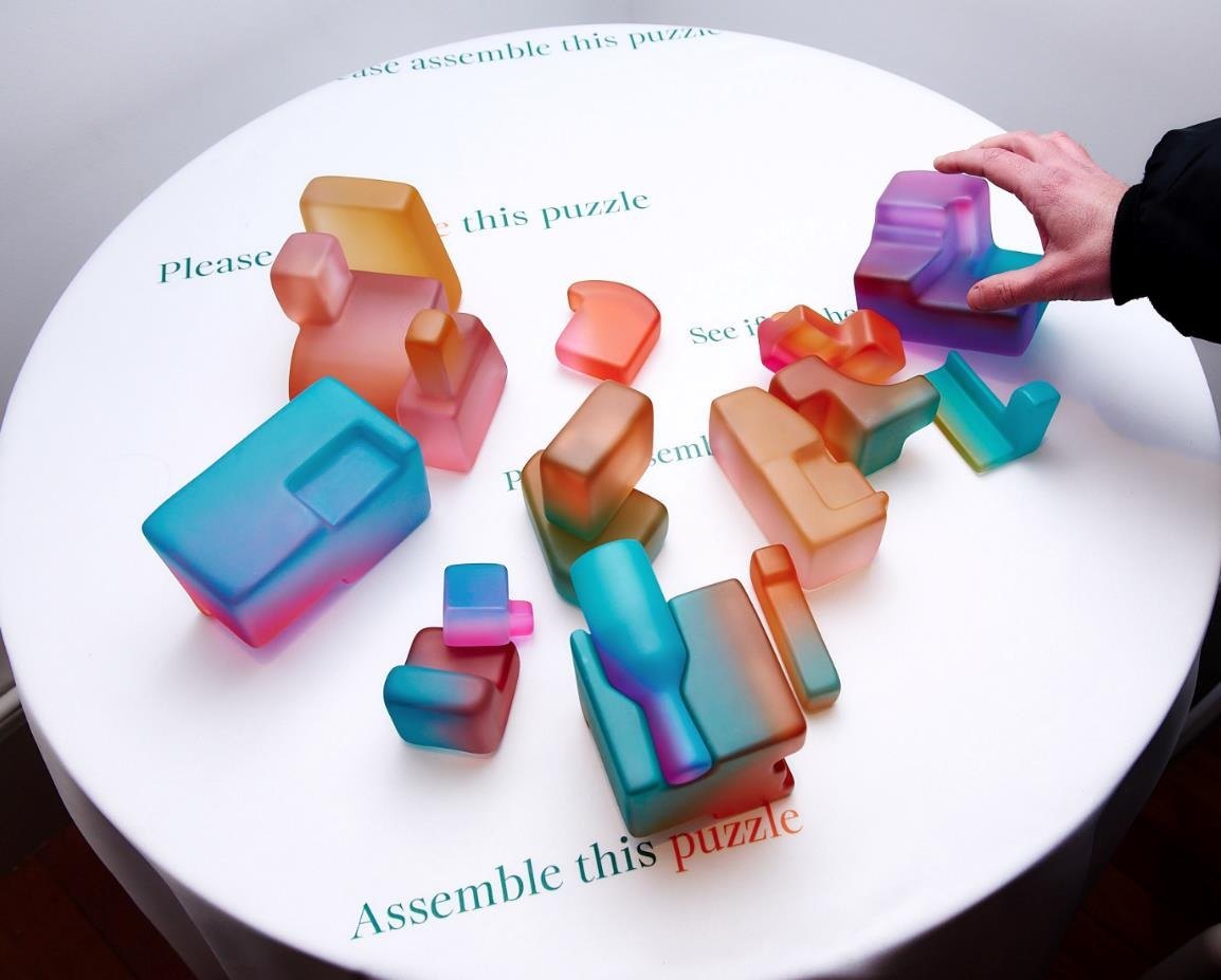 A visitor rearranges the sculptural fragments.