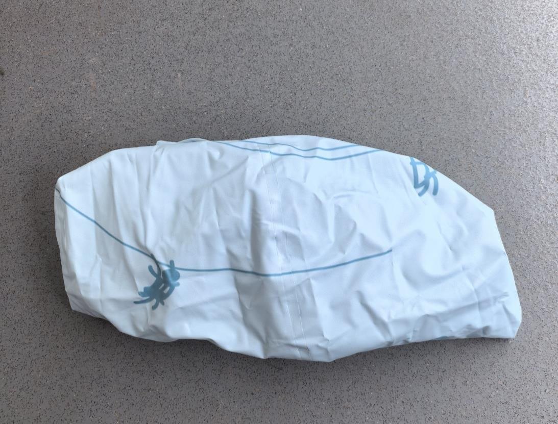 A soft form after deflation, retaining folds and temporary traces of handling.